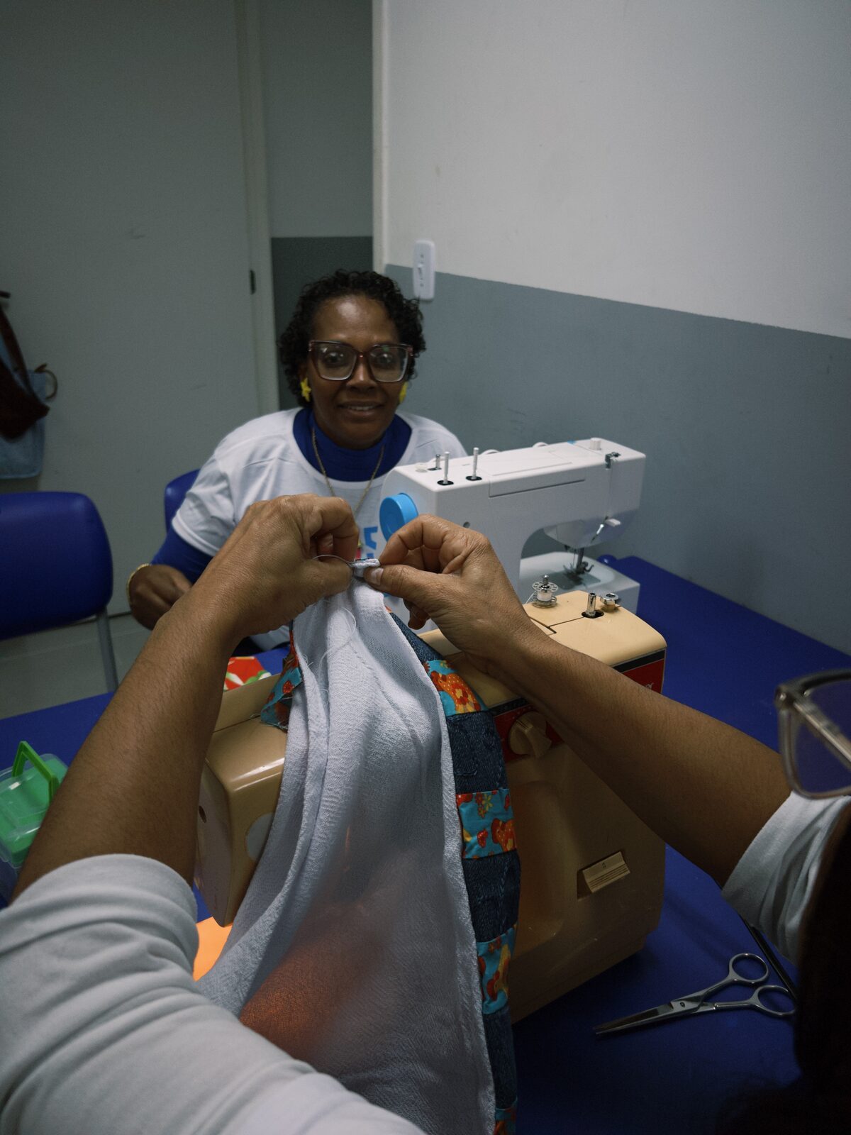 Aluna costurando uma peça na máquina durante a oficina