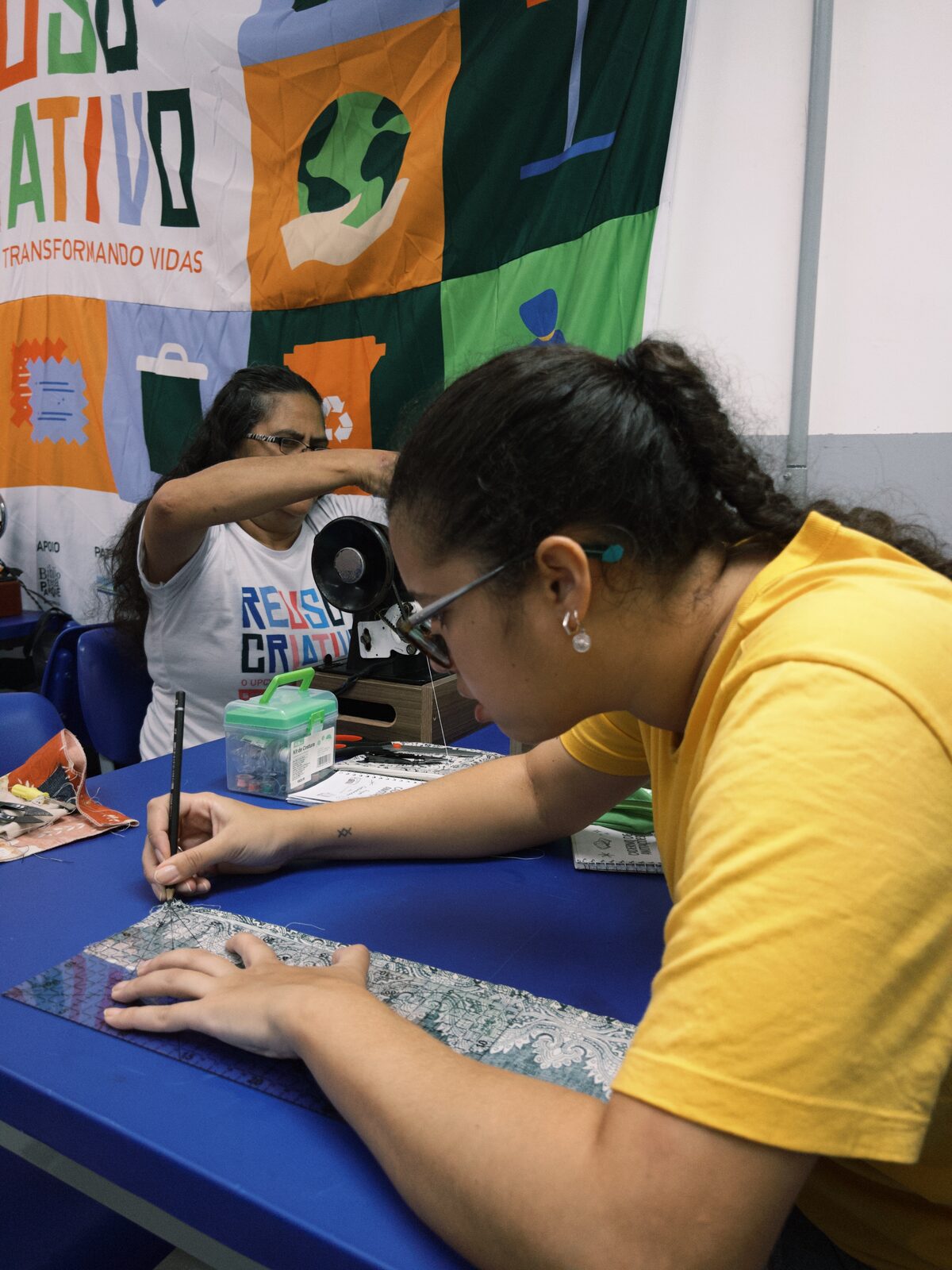 Aluna desenhando um molde com orientação da professora